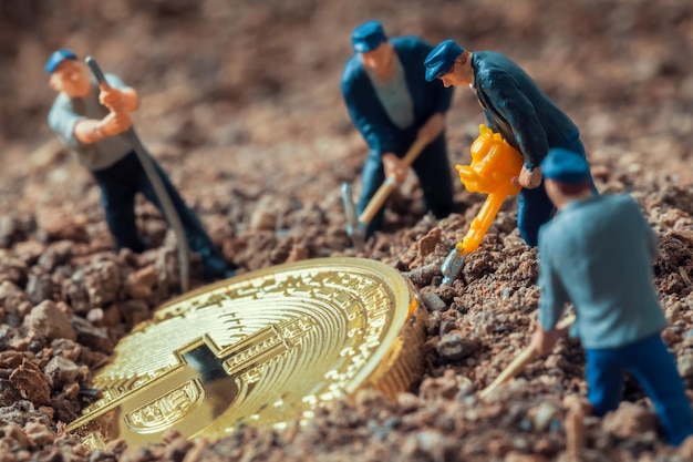 estatuetas de macro mineradora cavando terreno para descobrir grande bitcoin brilhante