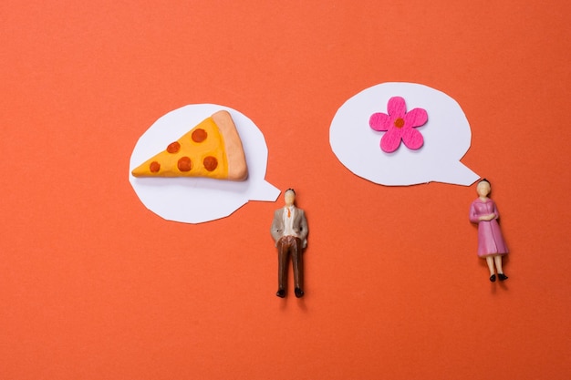 Estatuilla de hombre y mujer pieza de pizza de flor falsa y mini burbujas de discurso recortadas de papel