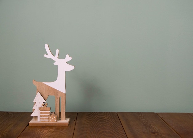 Estatuilla de madera en forma de ciervo sobre fondo verde Concepto de Navidad