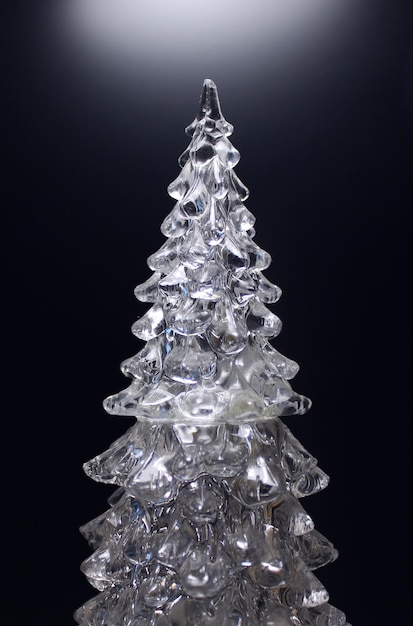 Estatuilla transparente que se asemeja a un árbol en un fondo negro vertical foto de archivo