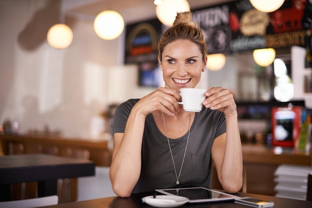 Este café está fazendo meu dia Uma bela jovem tomando café em uma cafeteria