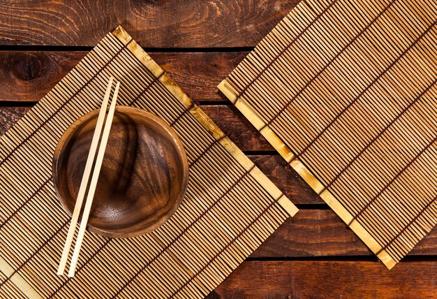 Foto esteira de bambu na vista superior da mesa de madeira