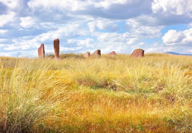 Estelas de pedra do século 5 a.C. entre a grama dourada sob um céu nublado Sibéria Rússia