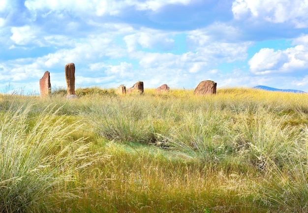 Estelas de pedra do século V aC entre a grama dourada sob um céu nublado Sibéria Rússia