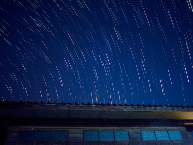 Foto estelas de estrellas en el cielo sobre un edificio