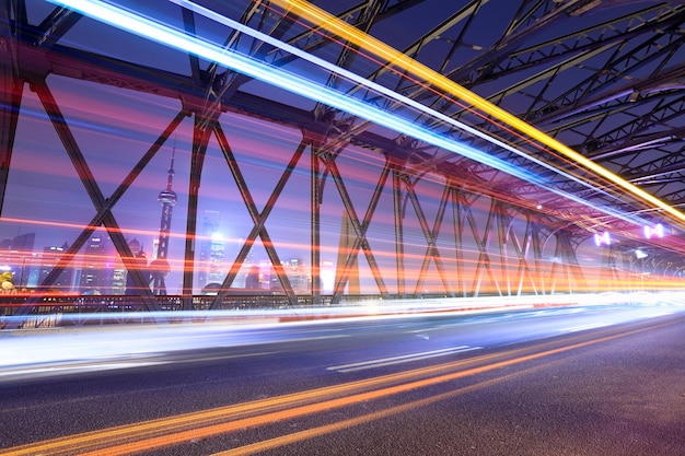 Estelas de luz a través del puente del jardín en shanghai