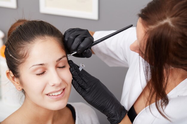 Esteticista aplica maquillaje permanente en las cejas