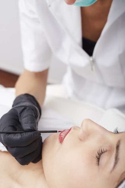 Esteticista aplica maquillaje permanente en los labios