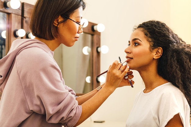 Esteticista aplicando maquillaje a una mujer en un spa de belleza