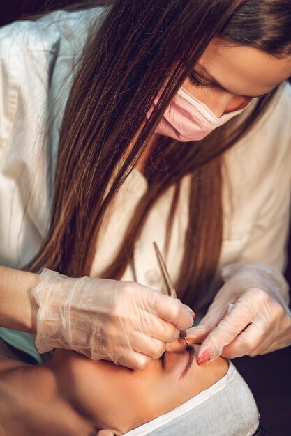 Esteticista aplicando el método japonés de dibujar en las cejas al modelo.