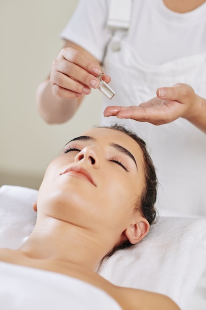 Esteticista aplicando óleo de massagem