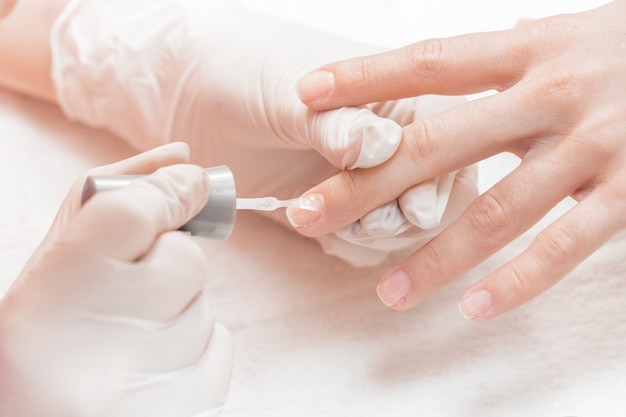 Esteticista aplicando uñas polacas a las mujeres