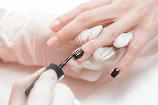 Esteticista aplicando uñas polacas a las mujeres