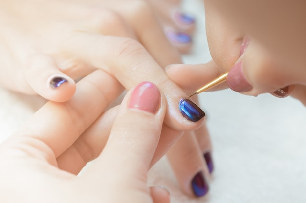 Esteticista aplicando uñas polacas a las mujeres