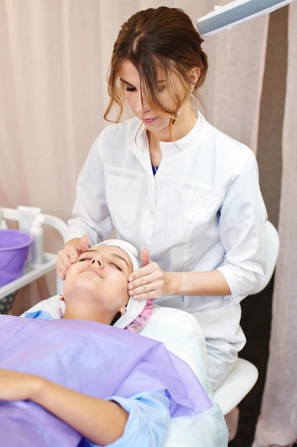 Foto esteticista chica trabaja con pacientes en la oficina.