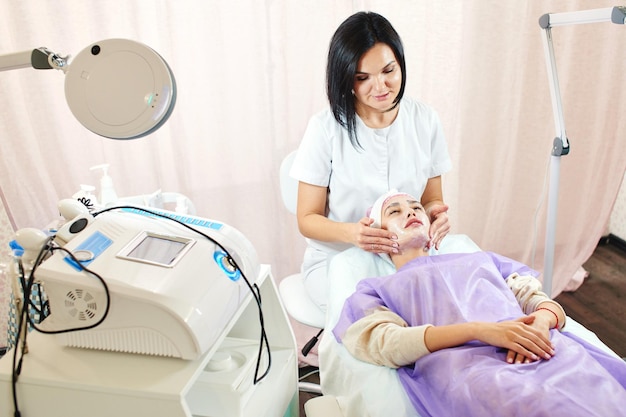 Esteticista chica trabaja con pacientes en la oficina.