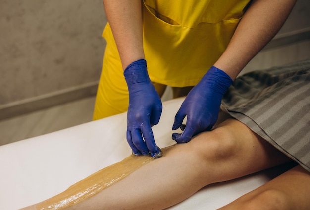 Esteticista depilação pernas femininas no centro de bem-estar