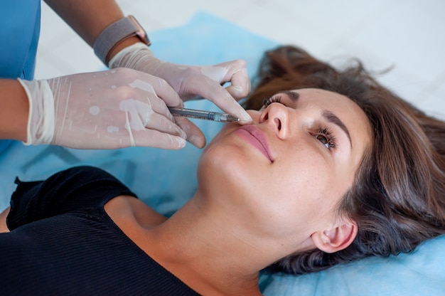 Esteticista e paciente na clínica de medicina estética. Injeção labial