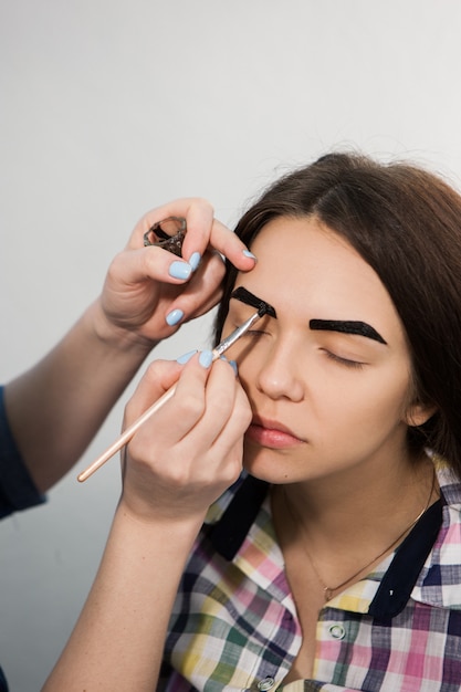 Esteticista está coloreando con henna frente de niña