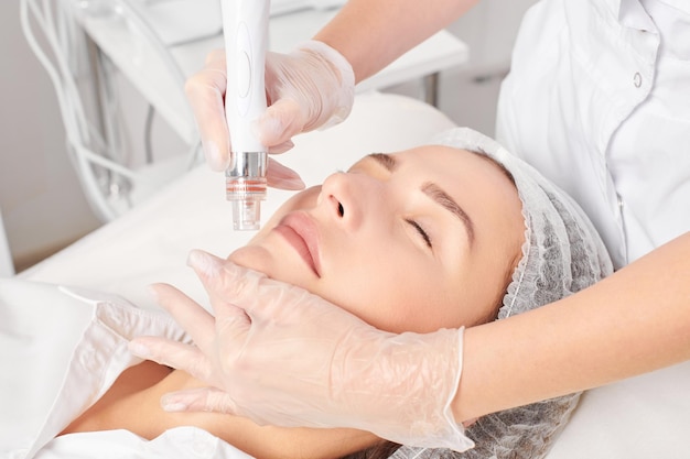 Esteticista faz esfoliação aquática para rejuvenescimento procedimento de cuidado de rosto feminino em salão de beleza