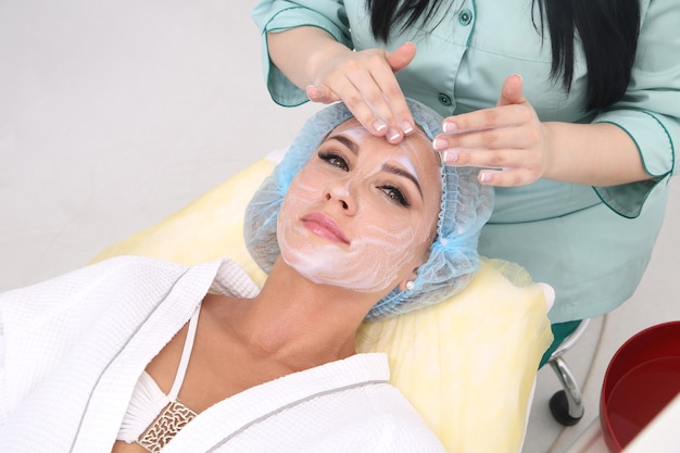 Esteticista faz limpeza e esfoliante facial para linda garota