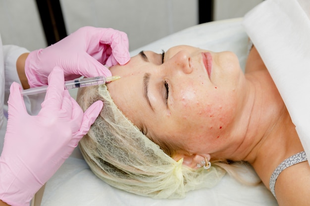 Foto esteticista fazendo injeção facial. procedimento de cosmetologia anti-envelhecimento revitalização