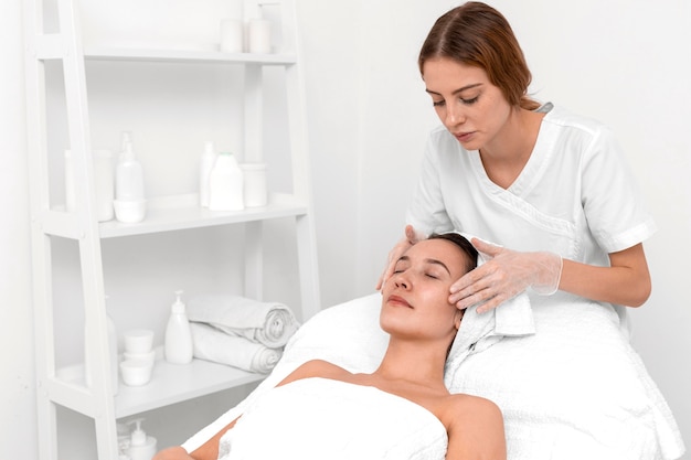 Foto esteticista fazendo rotina de beleza facial para cliente