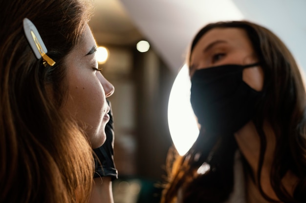 Foto esteticista fazendo um tratamento de sobrancelha para mulher