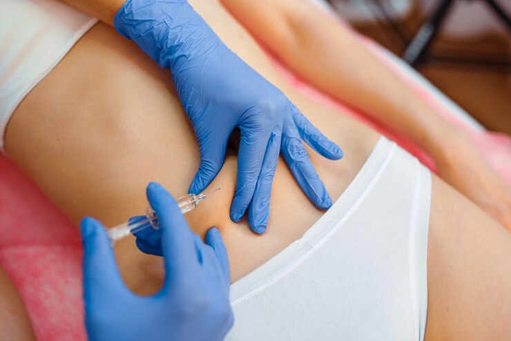 Foto esteticista en guantes da una inyección de botox en el estómago a una paciente en la mesa de tratamiento. procedimiento de rejuvenecimiento en salón de esteticista. médico y mujer, cirugía estética contra las arrugas.