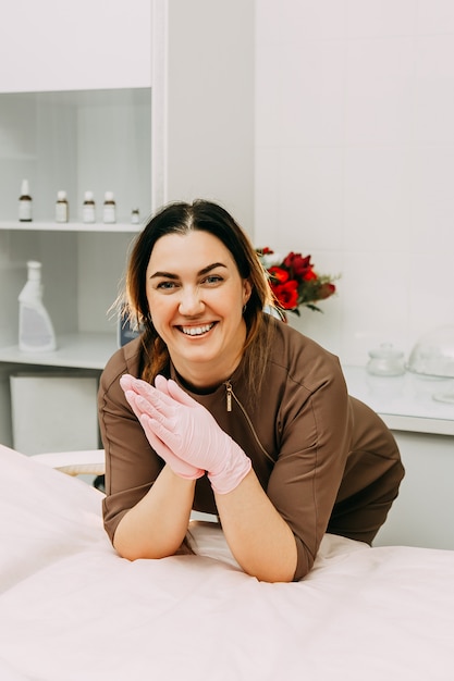 Esteticista con guantes sonriendo en la clínica