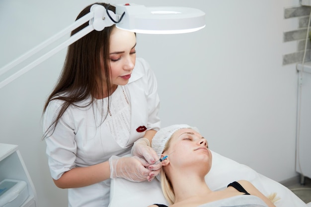 Esteticista hace inyecciones de mesoterapia spa tratamiento de belleza cuidado de la piel Mujer recibiendo cuidado facial por esteticista en el salón de spa vista lateral Centro de bienestar Ocupación de atención médica