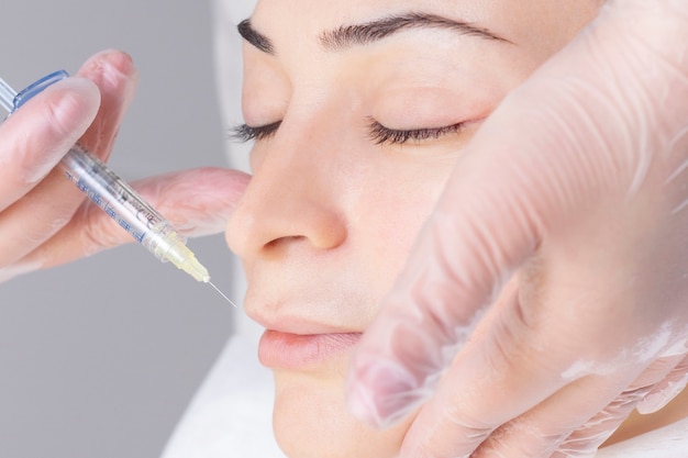 Esteticista, injetando colágeno nos lábios