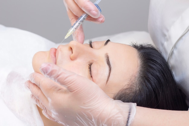 Esteticista inyectando colágeno en los labios