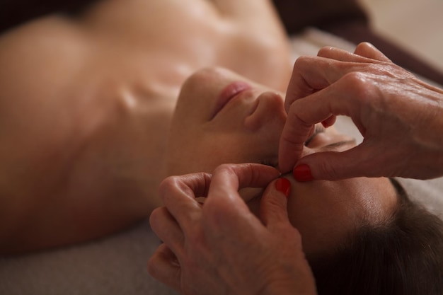 Esteticista masajeando las cejas de una clienta