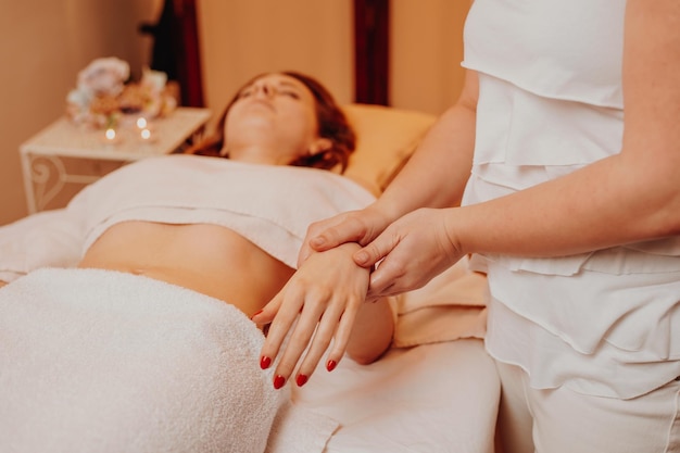 Esteticista massageando a mão da mulher no conceito de estilo de vida e saúde do salão spa