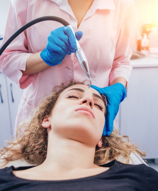 Esteticista y el paciente en la clínica de medicina estética que reciben un tratamiento.