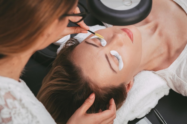 Esteticista preparando modelo para aplicar pestañas extendidas.