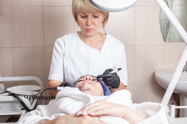 esteticista realizando procedimento de microcorrente no cliente