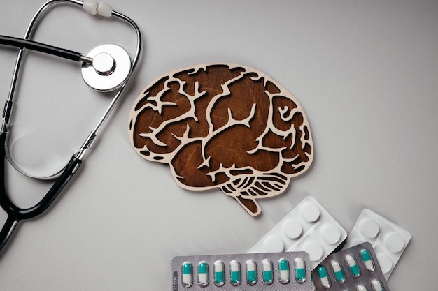 Foto un estetoscopio y cerebro con pastillas vista superior conciencia de la demencia de la enfermedad de parkinson de alzheimer