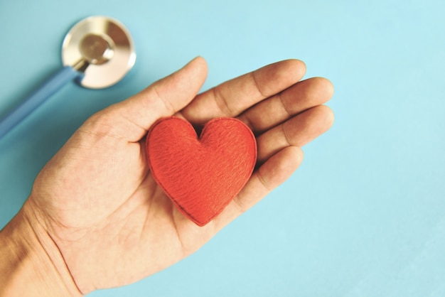 Estetoscopio y corazón rojo en mano