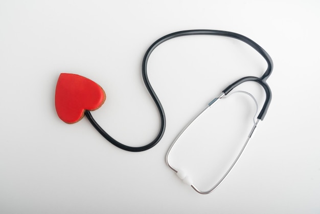 Estetoscopio y corazón rojo sobre fondo blanco. Sigue a tu corazón. concepto de salud.