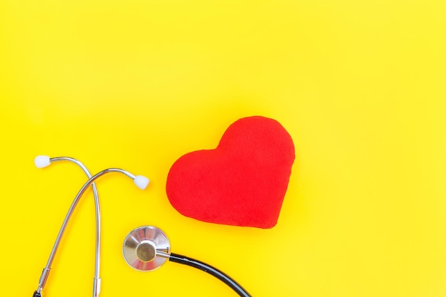 Estetoscópio de equipamento de medicina ou estetoscópio e coração vermelho isolado no fundo amarelo da moda