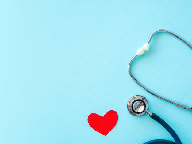 Estetoscopio del día del médico con un corazón rojo sobre un fondo azul con un lugar para el texto