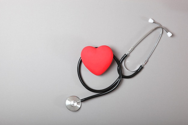 Estetoscópio e coração em fundo de madeira saúde medicina