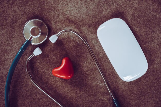 Foto estetoscópio e coração mouse de computador