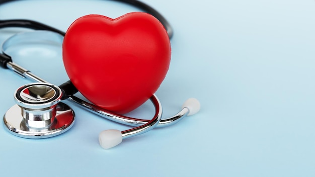 Estetoscópio e forma de coração em fundo azul Conceitos médicos e seguros