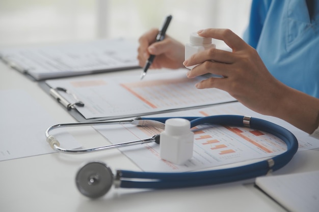 Estetoscópio e médico de fundo usando laptop na mesa da clínica trabalhando no computador no escritório da sala