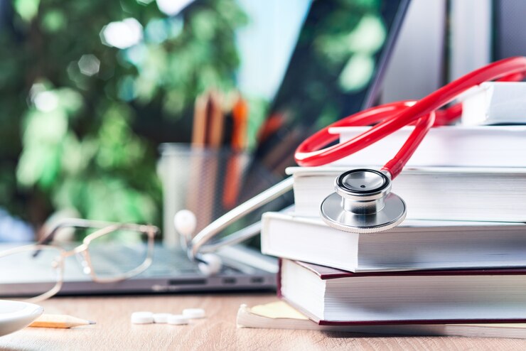 El estetoscopio está sobre libros de medicina,