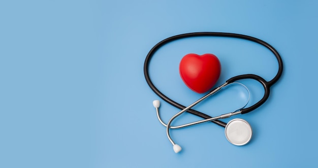 Estetoscopio y examen del corazón rojo sobre fondo azul concepto sanitario