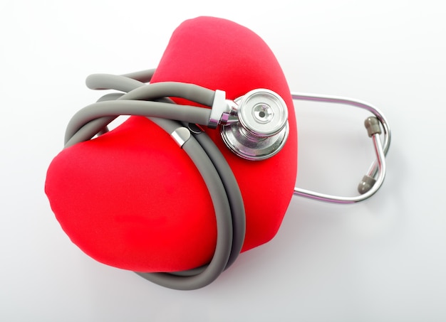 Estetoscópio médico com coração vermelho isolado no branco